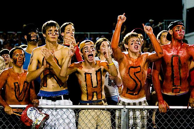 Football fans with painted bodies cheering