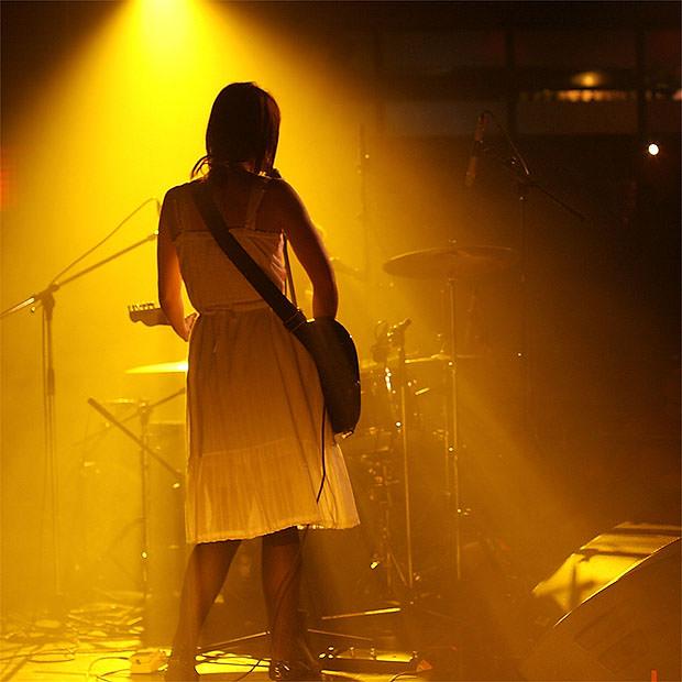 Female guitarist lit in yellow