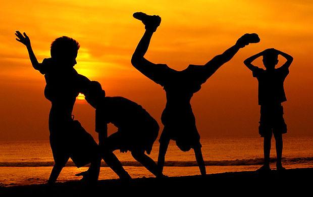 Four boys playing against a sunset background