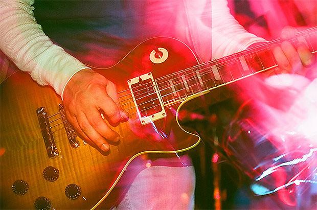 Slow sync flash photo of a man playing the guitar