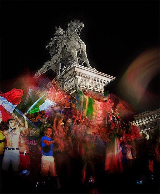 Slow sync flash photo of football fans next to a statue