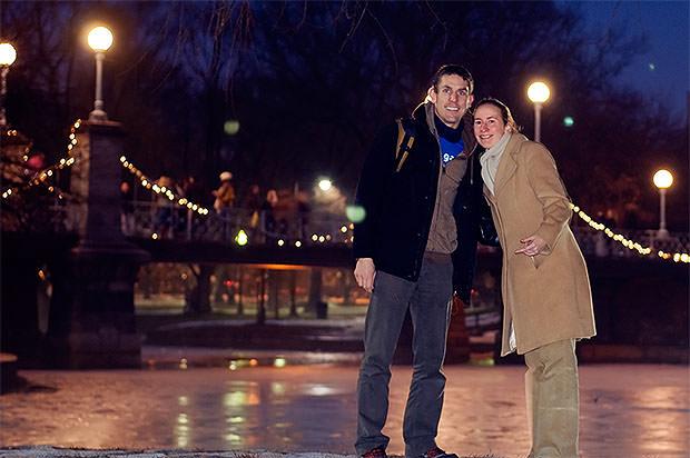 A couple standing in front of a bridge at night